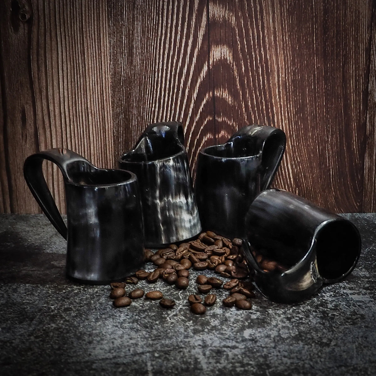 Set med fyra espressomuggar – alla fyra muggar med kaffebönor, mot trävägg