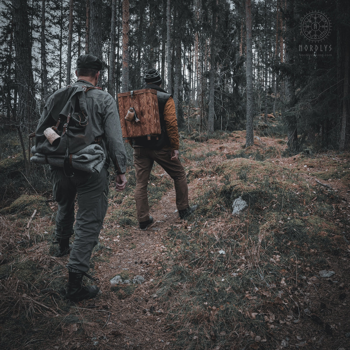 Two people seated outdoors at night using handfelted wool blankets for warmth, demonstrating outdoor camping use