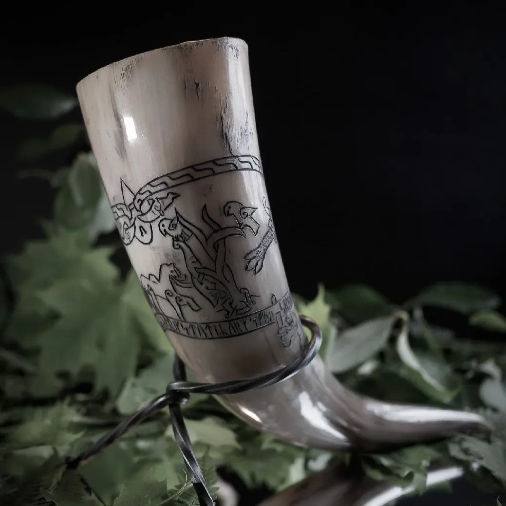 Naturligt tjurhorn med gravererad Sigurdsagan från Eskilstunarunstenen. Hornet visar vita och kremfärgad hornyta med detaljerade svarta graveringslinjer som skildrar den legendariska sagan med warrior- och drakfigurer. Nordisk narrativ konst med runoinspirerad design.