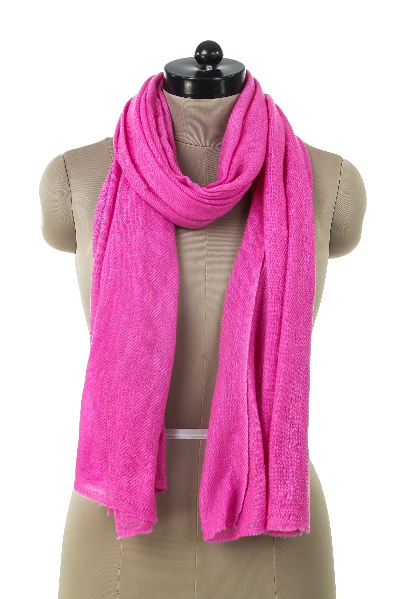 Pink cashmere shawl in soft wool material, draped on a tailor's dummy and showing elegant drape and fine knit quality