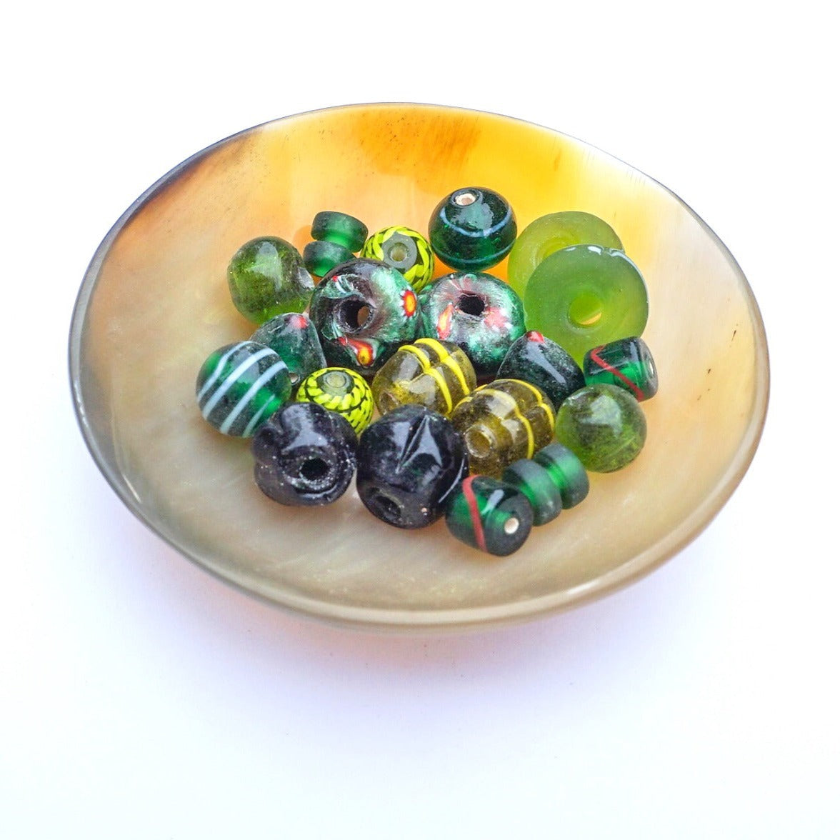Blandning av olika handgjorda glaspärlor i gröna toner med eller utan dekor i andra färger. Pärlorna är kopior av olika fynd från vikingatiden. Pärlorna är olika i fomren och några är däckformade, andra är runda. Det är även en blandning av milifioripärlor och pärlor med pålagda enklare mönster.