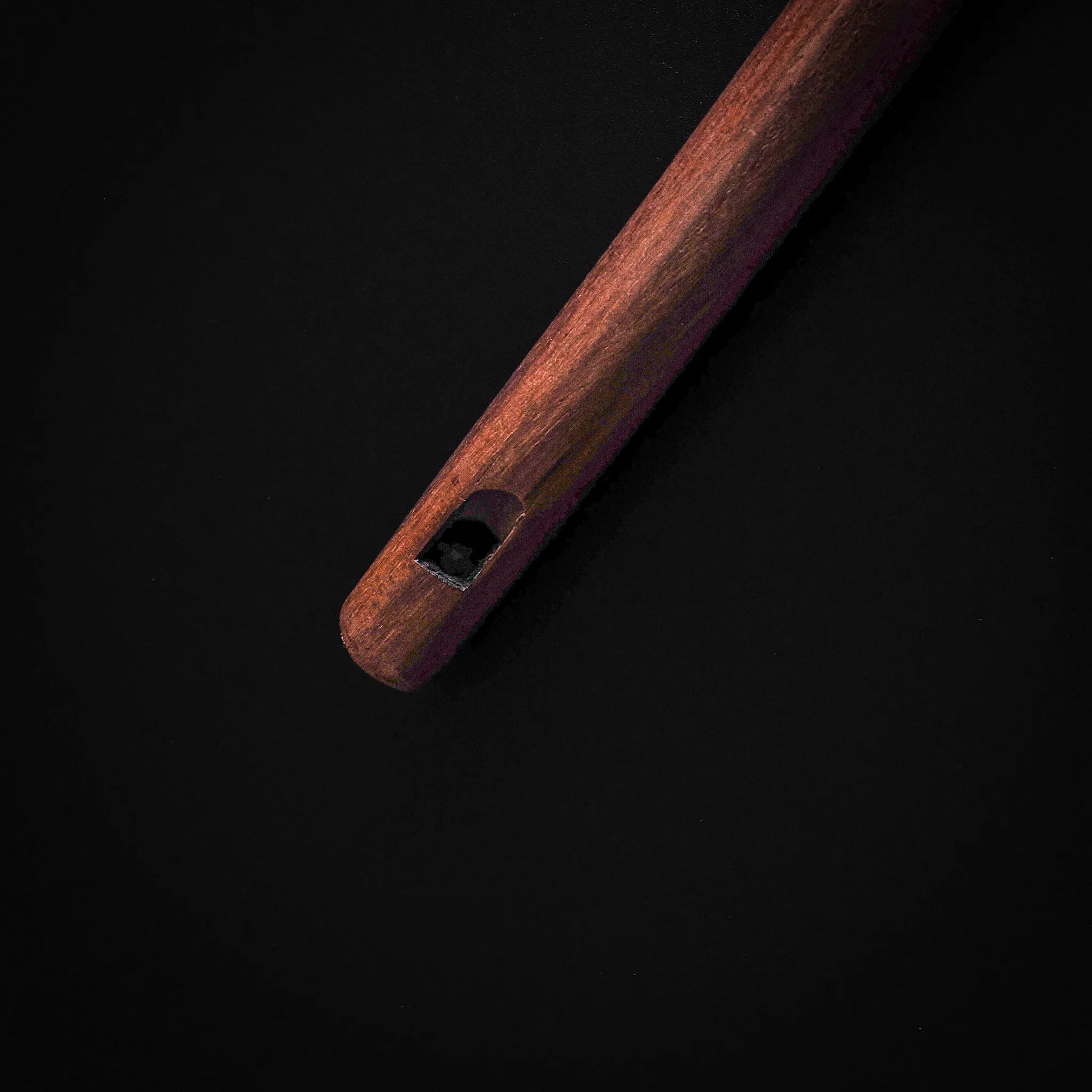 Närbild av träflöjtens botten med dekorativ ringdetalj