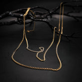 Close-up of silver-plated brass chain by the meter with twisted links and shimmering finish against dark background