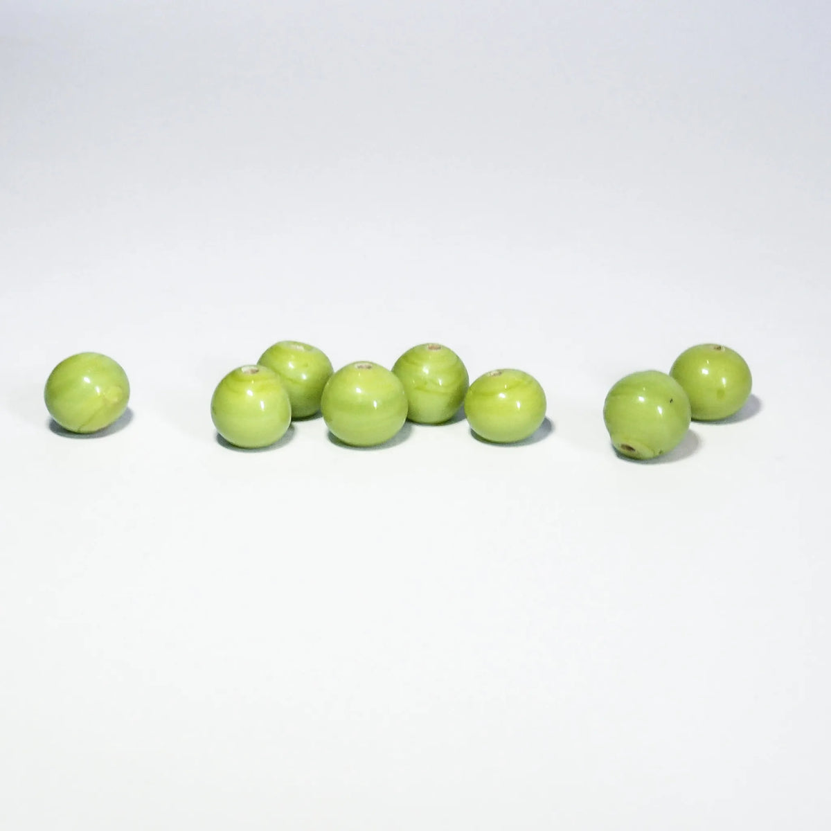 Light green (lime-colored) round glass bead – several beads, the smooth glossy surface visible