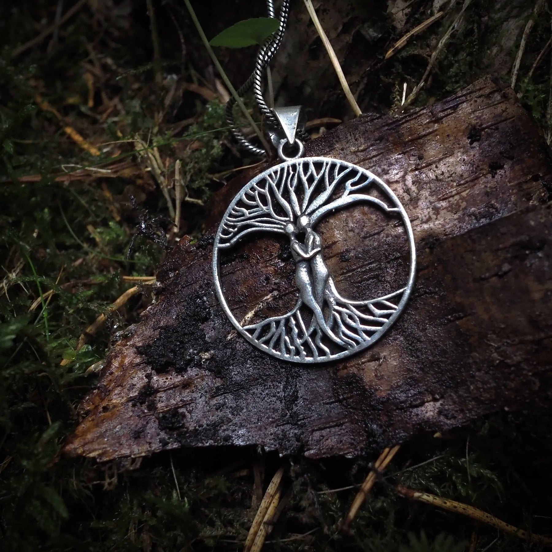 Ask and Embla amulet, large – silver-coloured pendant on chain, close-up in forest setting