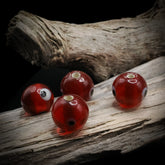 Red glass bead Birka – four beads with eye decoration, holes and eyes visible from different angles