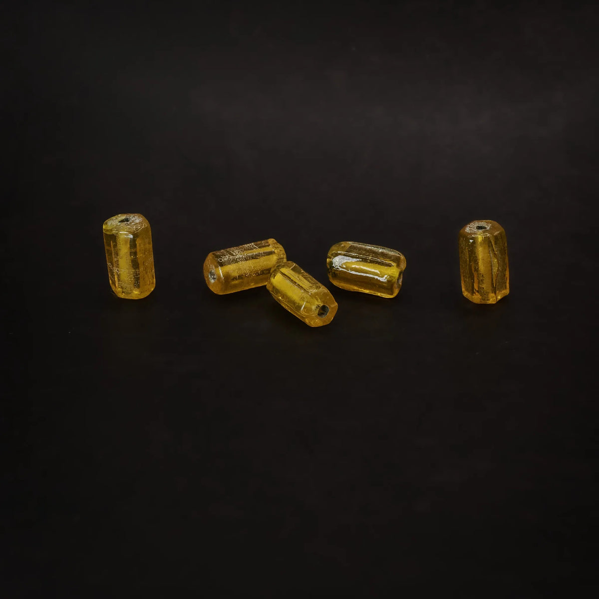 Avlång mörkgul glaspärla