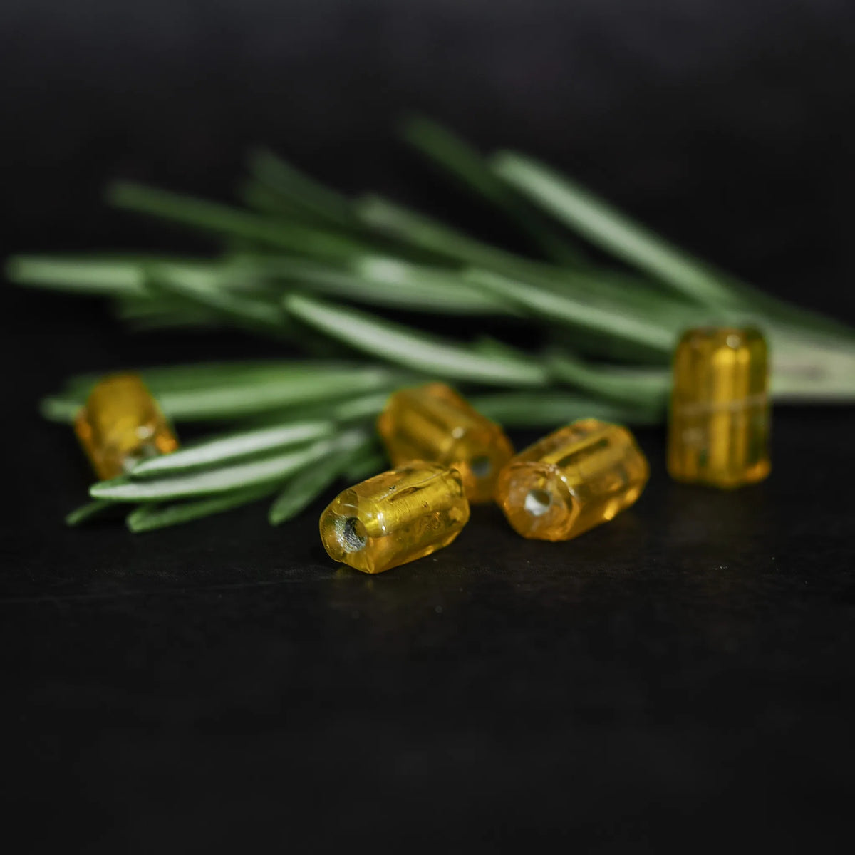 Avlång mörkgul glaspärla