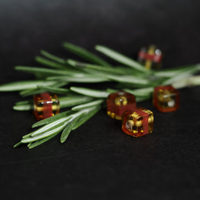 Kubisk mörkgul glaspärla