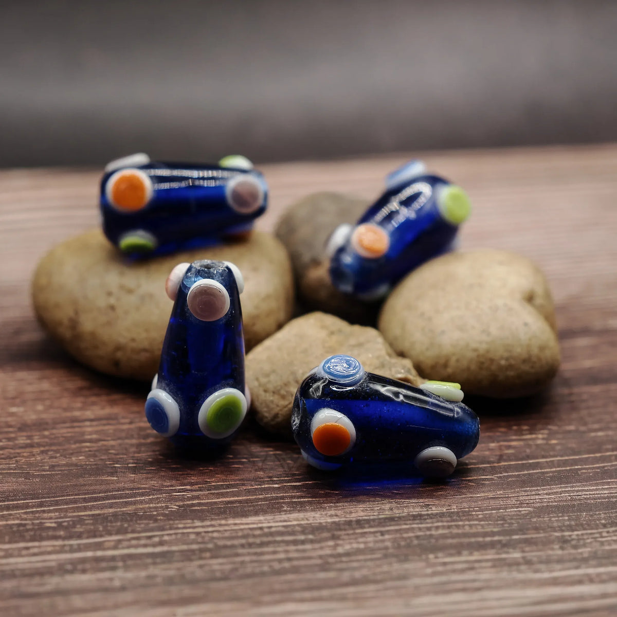 Blå, konformad pärla med prickar i starka färger