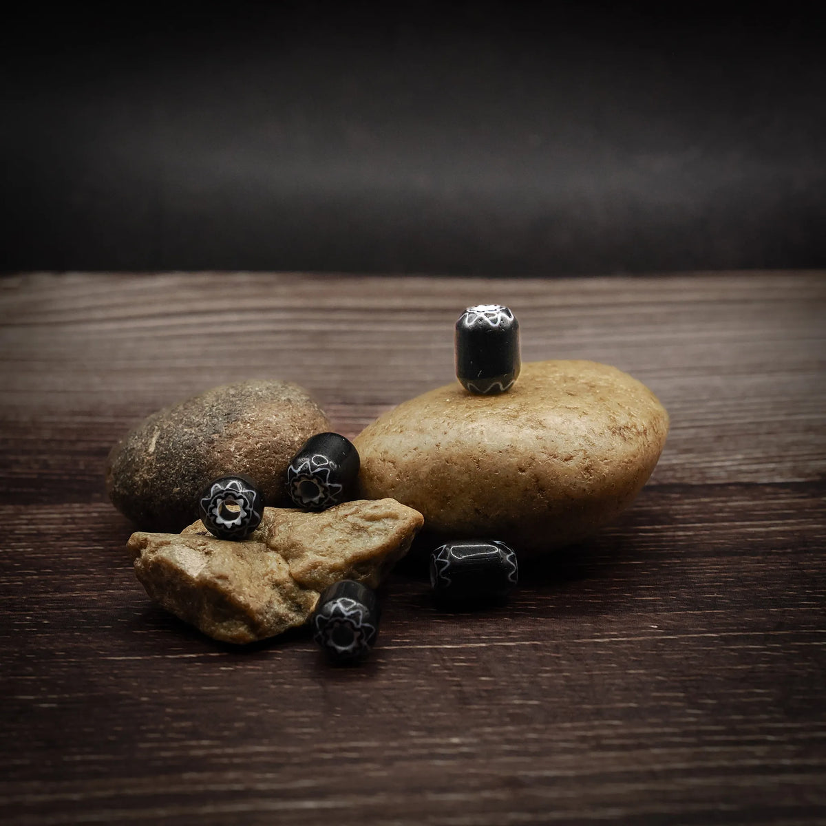 Svart, avlång glaspärla med mönster