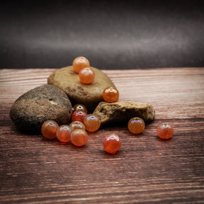 Orange glaspärla med pärlemorsken