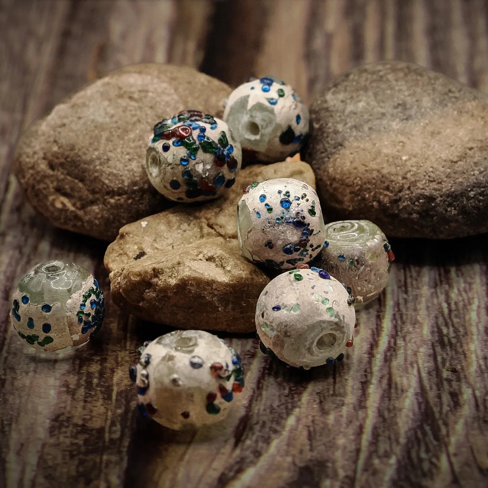 Rund glaspärla med konfetti  prickar, produktbild visar designen och materialet.