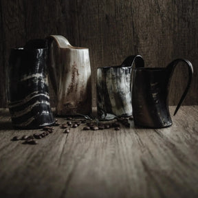 Kaffemugg i horn – fyra muggar i olika nyanser och mönster uppställda bredvid kaffebönor