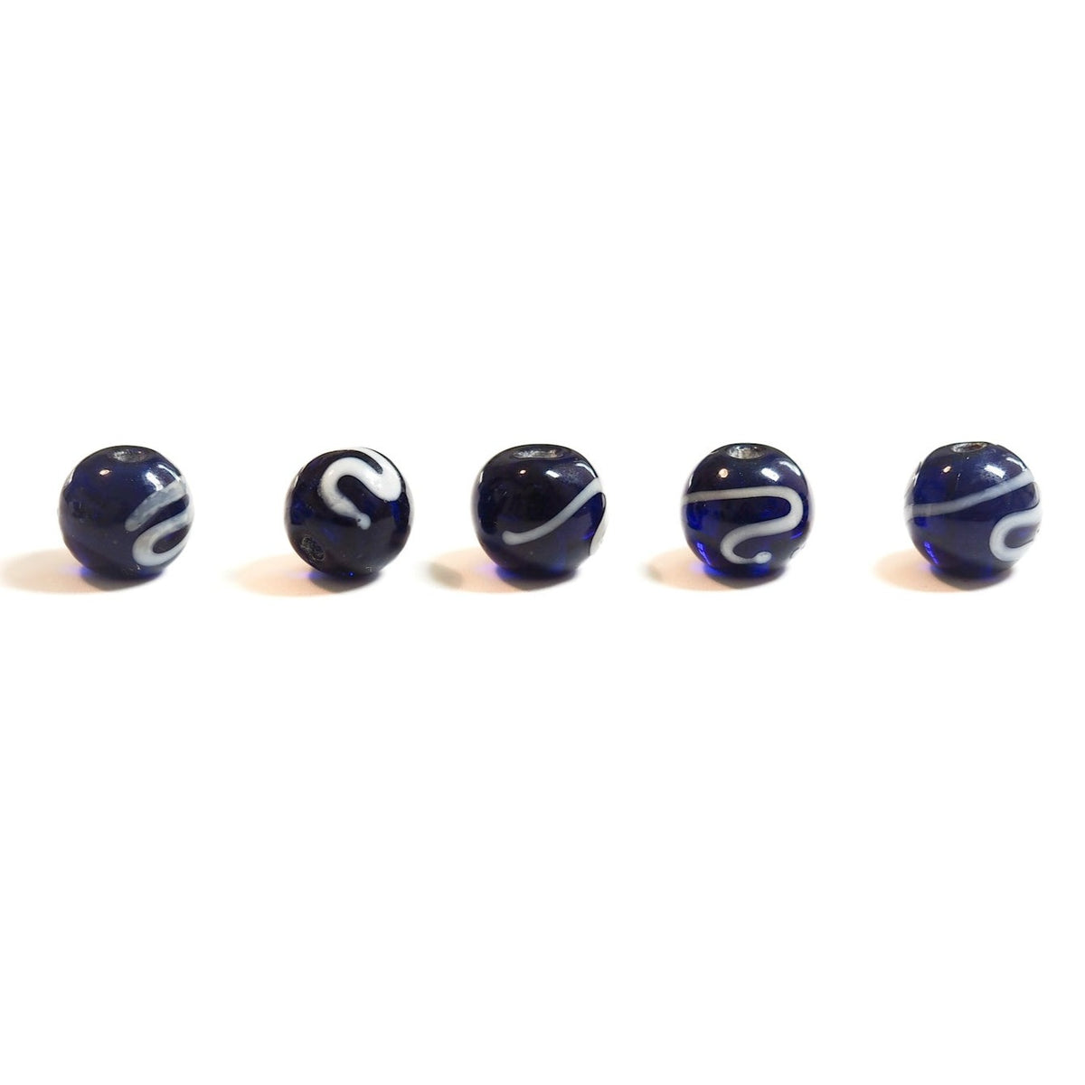 Glass bead, blue with white decoration.