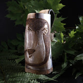 Hornmugg med vikingskepp, fotograferad från sidan för att visa skärningens detaljer och skeppets segel.