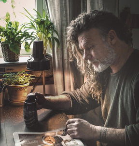 Stor kaffemugg i horn – mörk marmorerad mugg på bord bredvid man som läser tidning