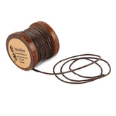 Brunt läderband på traspole - 1mm tjockt, 5 meter långt, från Nordlys Viking. Träspolen visar märkning med produktdetaljer. Läderkordet är delvis upprullat mot vit bakgrund.