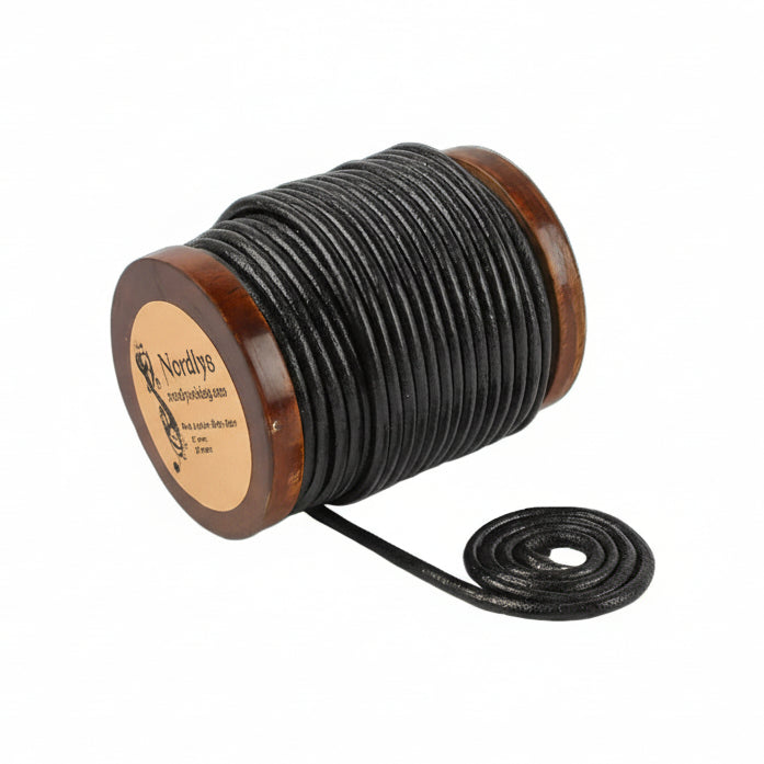 Svart läderband på träspole fotograferat från sidan, visar både upprullad och utdragen sträng