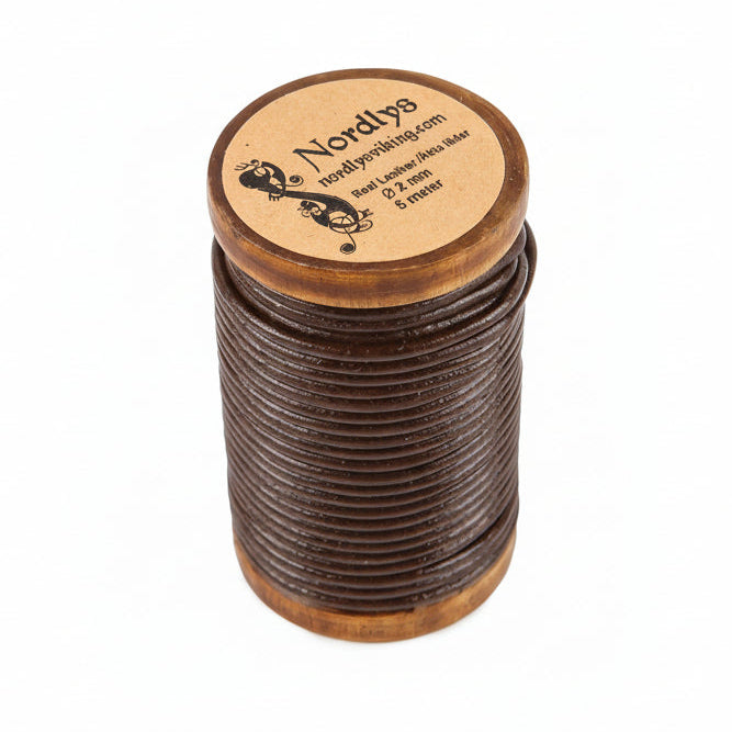 Brunt läderband på träspole - visar 2mm tjockt kalvskinn från Nordlys Viking, upplindat på trätrommel med märkad etikett